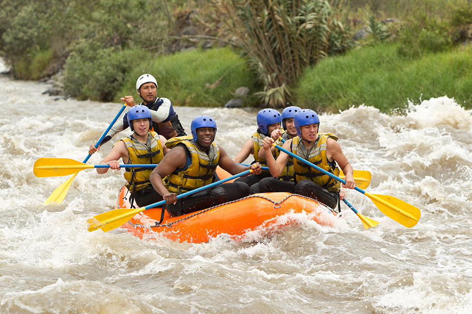 A GROUP OF MEN AND WOMEN, WITH A GUIDE, WHITEWATER RAFTING ON THE PATATE RIVER, ECUADOR