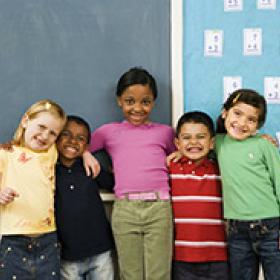 group of diverse young students standing together in classroom 