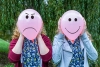 Two teenage girls holding balloons with facial expressions outdoors